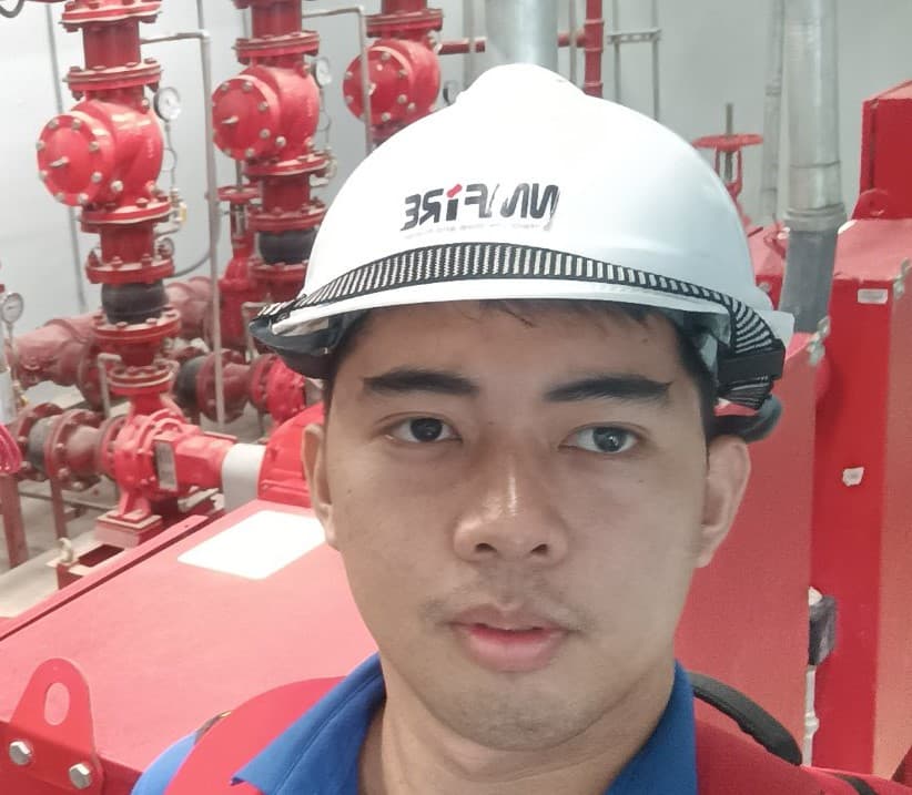 Renzo on site at a fire pump room, wearing a hard hat